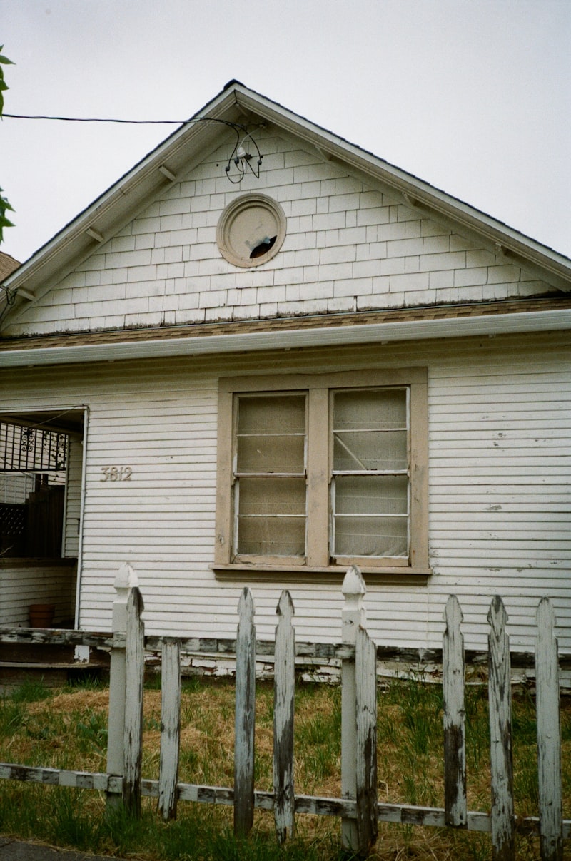 Neglected older home with weathered fence